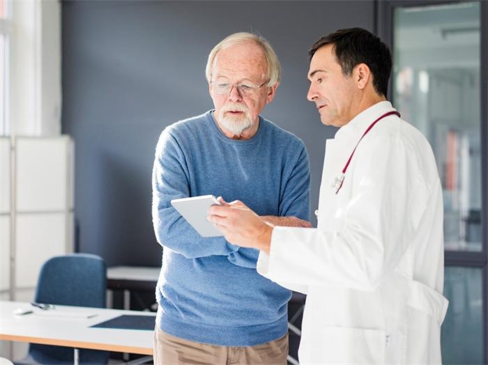 Doctor discussing prostate cancer treatment plan with patient during medical consultation