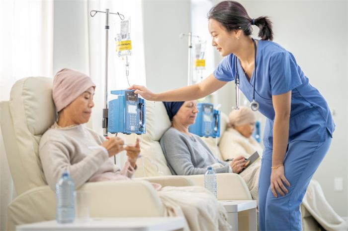 Oncology nurse checking an infusion pump during supervised chemotherapy treatment