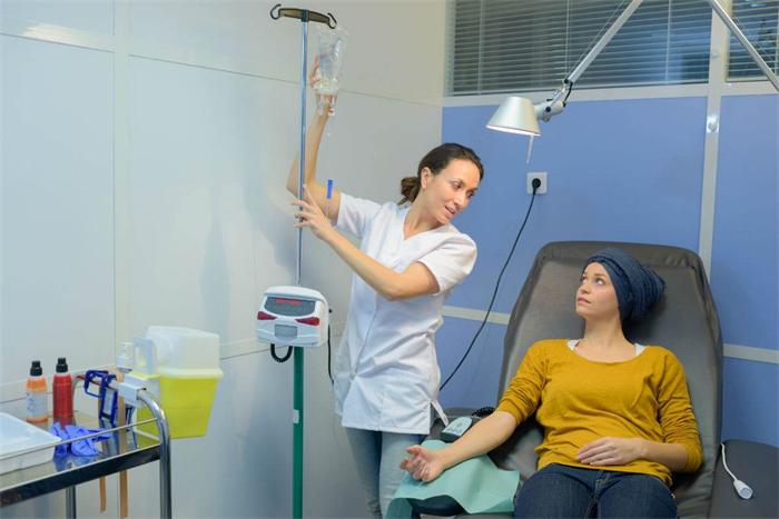 Oncology nurse monitoring a patient during intravenous chemotherapy infusion