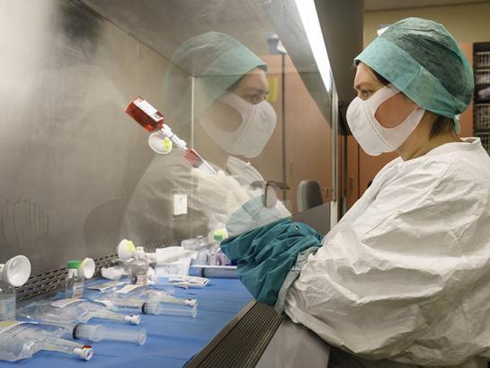 Pharmacy technician preparing chemotherapy medicine in a biological safety cabinet